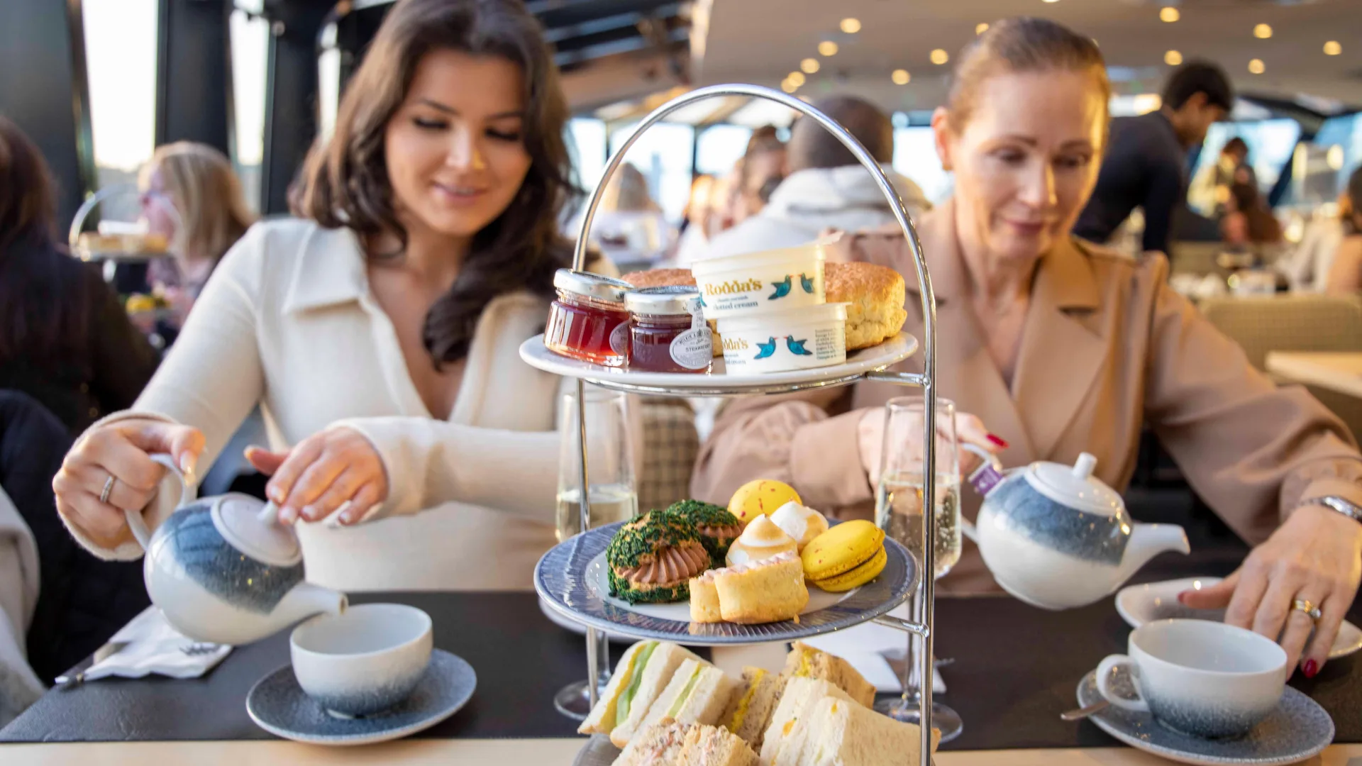 An afternoon tea stand with sandwiches, scones and cakes on a Thames cruise, from the afternoon tea cruise listing